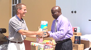 (L-R) Dennis Thomas hands over donation for inmates at the Prison Farm to Permanent Secretary in the Premier’s Ministry Wakely Daniel on August 07, 2014